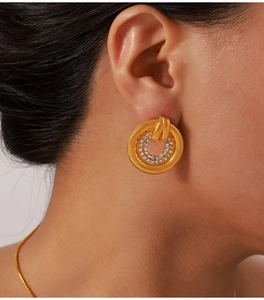 Close-up of elegant gold plated hollow earrings with double round crystal inlay