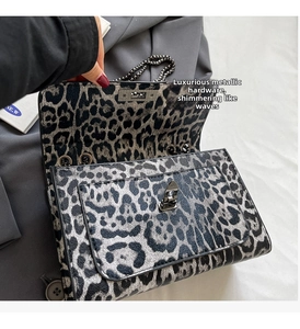Detail der Tasche mit Leopardenmuster, silbernem Drehverschluss und Kettenriemen