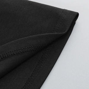 Gros plan sur l'ourlet à double couture de cette robe moulante noire à col montant