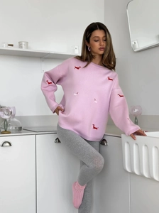 Detail view of pink knitted sweater featuring delicate dachshund puppy embroidery work