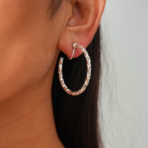 Close-up of silver geometric faceted ear cuff showing modern minimalist metal texture