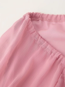 Detail des rosa Chiffonkleids mit elastischem Bündchen und plissierter Stoffstruktur