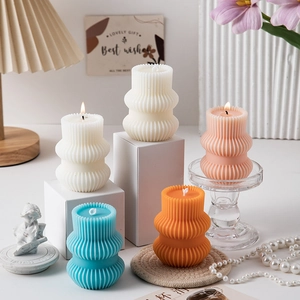 Detailed view of vertically pleated column candles in various soft pastel colors