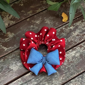 Elastico per capelli retrò a pois rossi con fiocco in denim blu su legno vintage