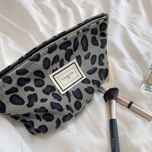 Detail of vintage leopard print corduroy makeup bag with zipper and logo label