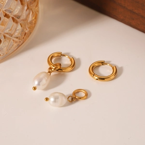 Golden titanium steel hoop earrings with freshwater pearl charms in a minimalist design