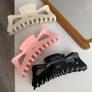 Vue à plat de pinces à cheveux en acétate crème, rose et noir avec Barrette La France