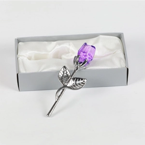 Detail of a purple crystal rose with silver metallic stem in a white satin gift box