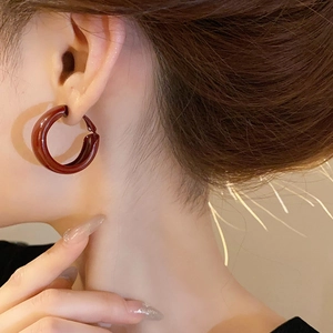 Close-up of a minimalist vintage amber resin hoop earring worn on a female ear