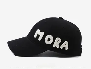 Detail of white 3D MORA lettering with textured embroidery on black cotton baseball cap