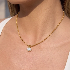 Elegante collana in acciaio al titanio dorato con ciondolo in zircone tondo indossata