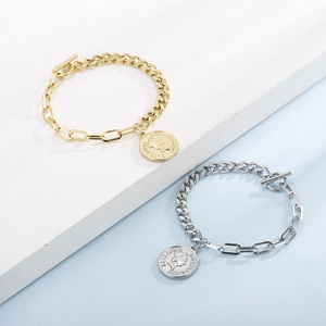 Détail de bracelets à maillons mixtes avec pendentif pièce de monnaie et fermoir à bascule