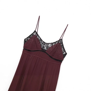 Burgundy slip dress featuring black lace trim and pleated hem on a white background