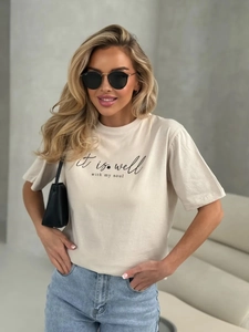 Λεπτομέρεια από κρεμ βαμβακερό t-shirt με την καλλιγραφική επιγραφή 'it is well with my soul'