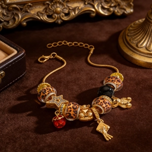 Close-up of leopard print beads and star charm on a luxury gold snake chain bracelet