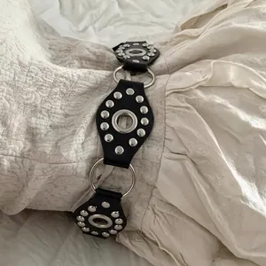 Y2K Punk black leather belt with silver rings and rivets on white fabric background