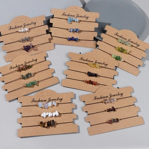 Close-up of three handmade natural gemstone bead bracelets on a brown display card