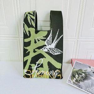 Detailed knit tote bag in dark green featuring white swallow and spring floral patterns