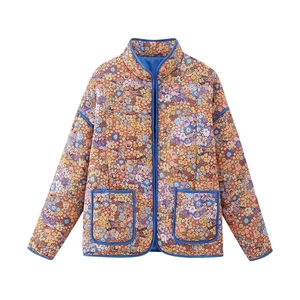 Détail de la veste matelassée fleurie avec bordure bleue et poches plaquées devant