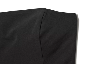 Detailopname van de zwarte textielstof en hoogwaardige stiksels op de bodysuit