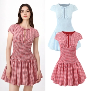 Detail of smocking waist and lace-up neckline on red and blue plaid mini dresses