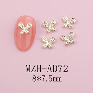 Macro shot of 8x7.5mm gold butterfly nail charms with rhinestones on pink nails