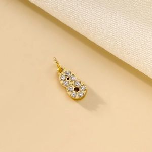 Detailed view of a gold-plated number 8 charm with micro-pave cubic zirconia crystals