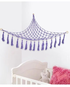 Close-up of purple hand-woven toy hammock with cotton tassels and decorative wood beads