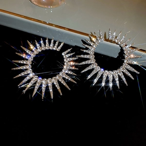 Detailed close-up of radiant sunburst hoop earrings with glittering rhinestones and silver finish