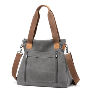 Minimalist grey canvas tote bag with brown handles and adjustable shoulder strap