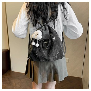 Detailed view of black pleated tote bag with butterfly print and plush cloud charm