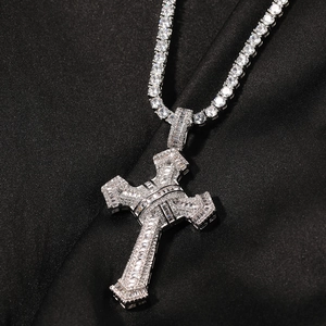 Macro shot of silver cross pendant with cubic zirconia on black textured fabric