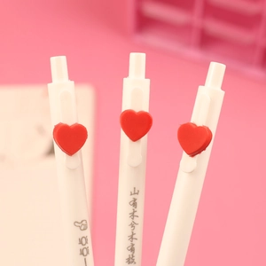 Close-up of white retractable gel pen with red 3D heart detail and poetic calligraphy