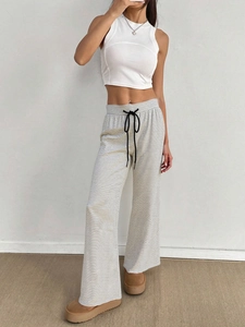 Detail of drawstring waist and black striped knit texture on loose wide-leg pants