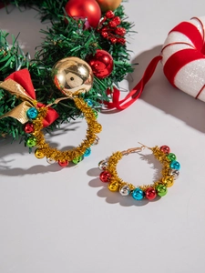 Detailed close-up of Christmas wreath hoop earrings with colorful balls and golden tassels