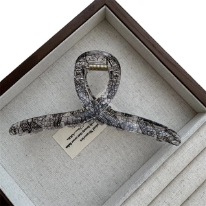 Elegant transparent acrylic hair claw with black lace mesh texture and gold spring detail