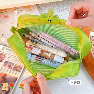 Green mesh storage bag with frog clip holding cartoon pens and stationery items
