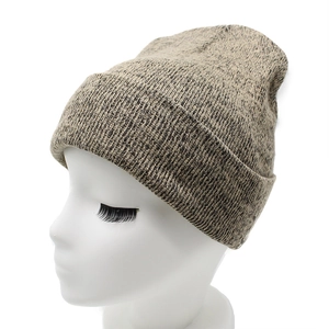 Close-up of thick ribbed knit texture on a melange grey and beige winter beanie