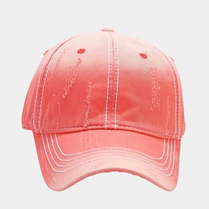Close-up of pink distressed baseball cap with white contrast stitching and frayed edges