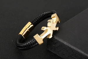 Macro detail of men's woven leather anchor bracelet with polished gold-plated buckle