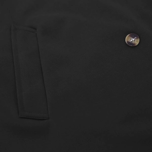 Detail of slim fit men's hooded trench coat showing pocket stitching and tortoise button