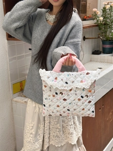 Close-up of quilted laptop bag with cartoon bear prints and delicate lace trim detail