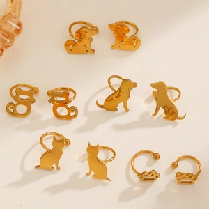 Golden stainless steel cat and dog paw ear clips collection for women shown on flat surface
