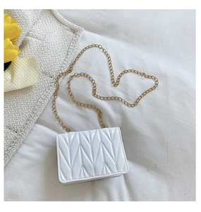 Detail view of white silicone heart bag featuring V-shaped embossing and gold chain strap