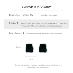 Détail macro de boucles d'oreilles géométriques en résine noire avec infos de taille