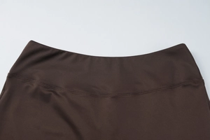 Détail macro de la taille en tricot extensible sur un pantalon de yoga marron foncé à coutures