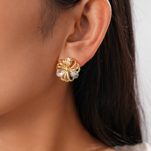 Detailed close-up of 18K gold plated hollow flower stud earrings with sparkling zircons