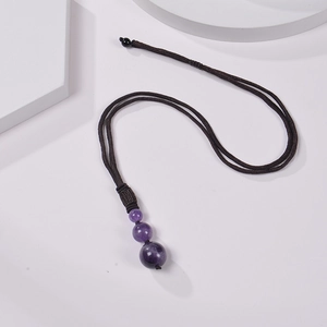 Detail of amethyst beads pendant on brown braided rope necklace over white background