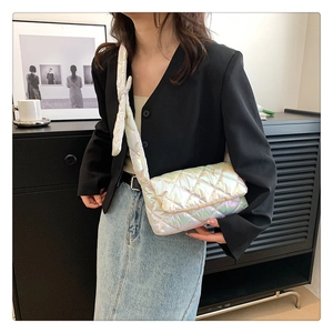 Detail view of a holographic quilted crossbody bag with a unique knotted shoulder strap