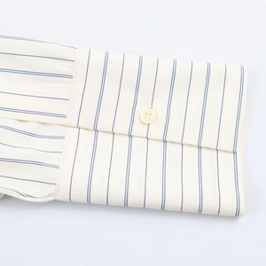 Detailed close-up of vertical blue stripes on cuff with white button on a striped shirt